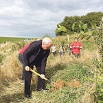 Westpac head, David McLean planting a tree on a Manawatu farm.