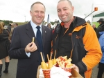 Prime Minister John Key pinches a chip from the lunch of Mark Hohneck at Fieldays.