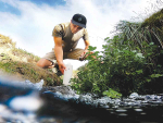 Programme co-lead Uwe Morgenstern takes a water sample from a spring-fed stream. Photo Credit: GNS Science