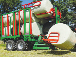 A hydraulically actuated “squeezer” grabs, lifts and rotates the bales up onto the trailer.