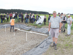 Hew Dalrymple pictured beside the woodchip bioreactor, which has been installed at the end of one of the drains on his farm.