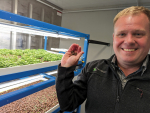 Alan Cottington with the Vertical Farm Systems display at SIAFD. The growing medium is porous clay pellets that contain biologically active microbes. Photo Credit: Nigel Malthus