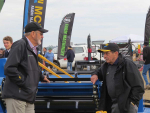 Founding director Bill McIntosh (right) at McIntosh Farm Machinery's Fieldays site solving the world's problems with Brian Hight.
