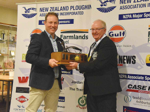 Ian Woolly (right) receives his trophy for winning the silver class at this year’s NZ Ploughing Champs from Nathan Winter of Farmlands Fuel.