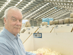 Allan Jones inspecting wool that is up for auction at the PGG Wrightson Napier Woolstore. Photo Credit: PGG Wrightson.